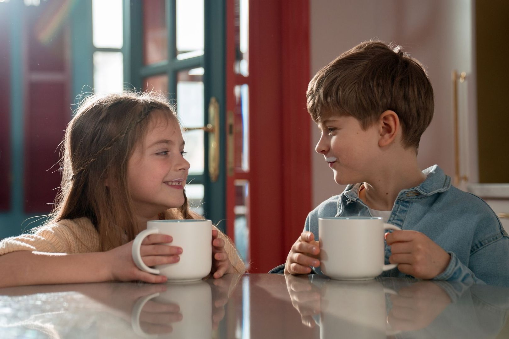 Twee kinderen drinken samen thee aan tafel tijdens een rustig moment
